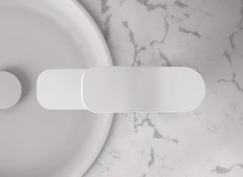 Eine Armatur der Serie Frattini FLÒ in matter Weißoptik ist auf einer eleganten Marmor-Waschplatte installiert.