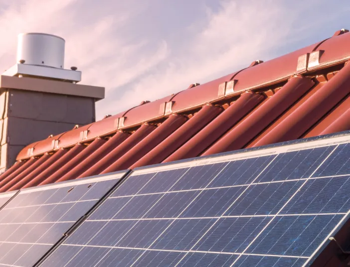 Solarmodule auf einem roten Ziegeldach.
