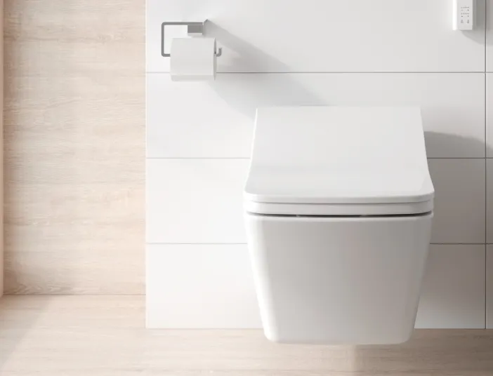 Ein modernes, wandhängendes Bidet-Toilettensystem in einem minimalistischen Badezimmer mit weißen Wandfliesen.